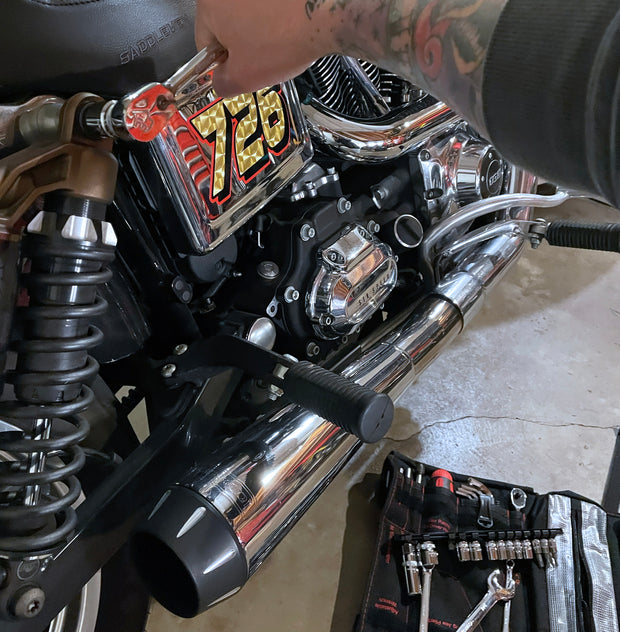 BoxoUSA Motorcycle tool roll in use during Harley-Davidson V-Twin maintenance with ratchet on suspension fastener
